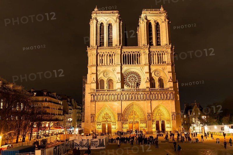 Notre dame cathedral stands illuminated, showing its prominent gothic architecture and intricate details under the night sky in the historic city of paris, france