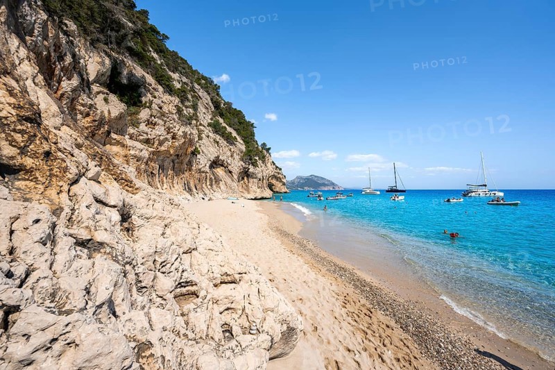 Sandy beach beach and steep cliffs at Cala Luna, Golfo di Orosei, Baunei, Sardinia, Italy