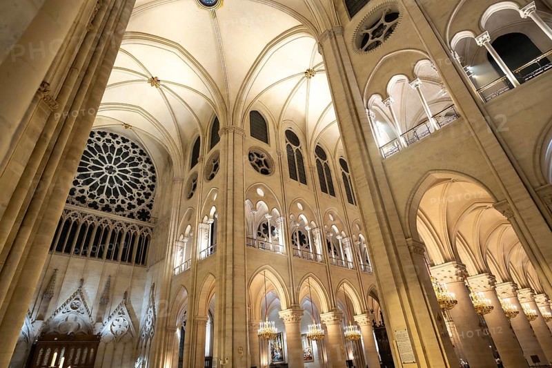 Notre dame cathedral interior in paris revealing soaring gothic vaults, towering columns, layered windows and a luminous rose window, bathed in soft, warm light