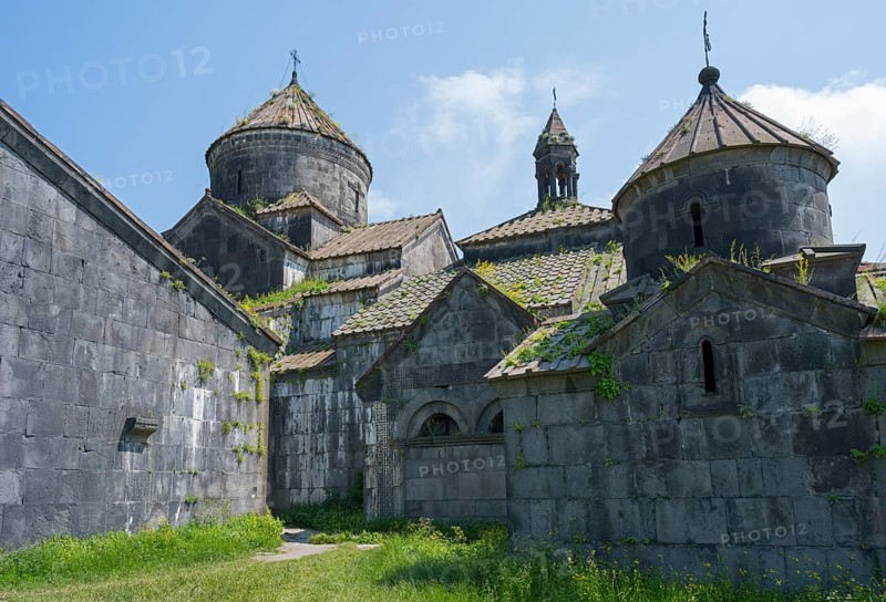 Impressive stone church towers with decorative details under blue skies and green vegetation, Haghpat Monastery, Haghpatavank, Haghpat Town, UNESCO World Heritage Site, Lorikeet Province, Armenia