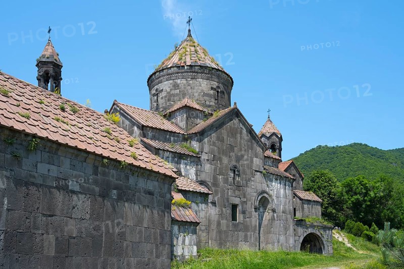 Old monastery building with stone structures and dome in front of a green mountain landscape, Haghpat monastery, Haghpatavank, town of Haghpat, UNESCO World Heritage Site, Lorikeet province, Armenia