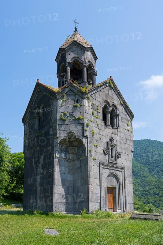 Small stone church with bell tower, surrounded by green nature and high-altitude mountains in the background, Haghpat Monastery, Haghpatavank, town of Haghpat, UNESCO World Heritage Site, Lorikeet Province, Armenia