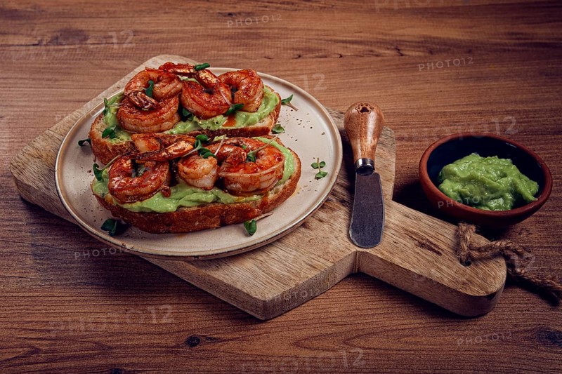 Sandwiches with avocado and caramelized shrimp, micro-greens, breakfast, on a plate, top view, homemade, no people