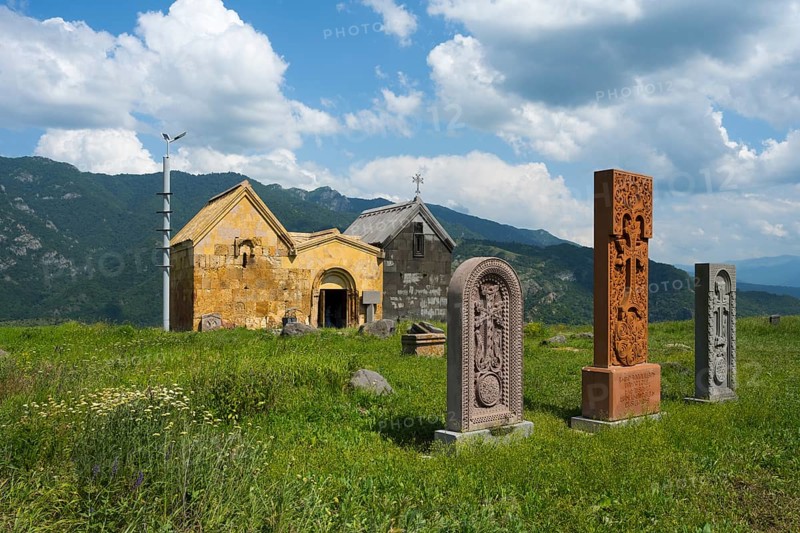 Church with stone sculptures in a green mountain landscape under a cloudy sky, Crossstones, Khachkar, Saint Nshan Church on Debed Gorge, Lorikeet Province, Armenia