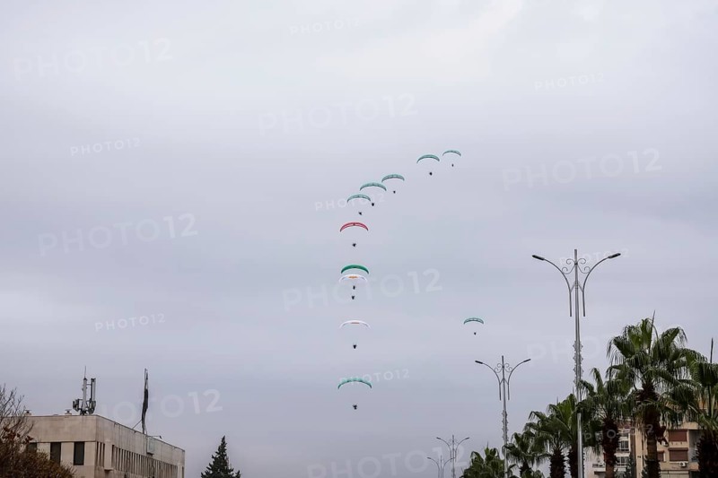 Damascus, Syria â€“ December 08, 2025: Paragliders display the Syrian flag during the first anniversary of the fall of Bashar al-Assad's regime, as hundreds of thousands gather in Umayyad Square to celebrate the historic moment, Damascus, Damascus, Syria