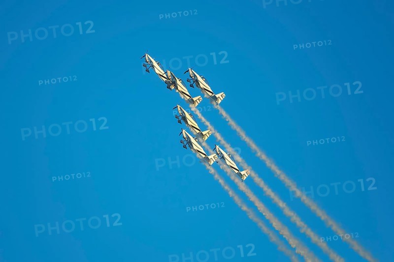 Stunt aerobatic planes performing stunts in blue sky with smoke trail. Concept of teamwork, collaboration, coordination, trust, precision, difficulty, challenge, speed, synergy