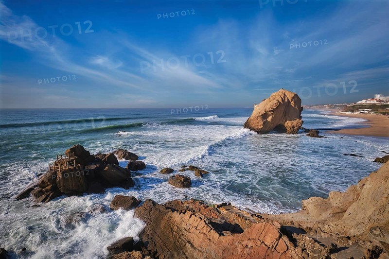 Penedo do Guincho, a large boulder rock arch at Praia da Santa Cruz, Portugal, with ocean waves and sandy beach