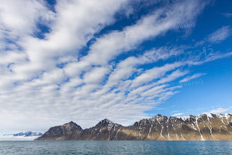 White clouds over mountains along Lilliehöökfjorden, fjord branch of Krossfjorden in Albert I Land, Spitsbergen / Svalbard, Norway