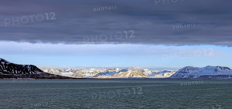 Snow covered mountains and glaciers debouching into Lilliehöökfjorden, fjord branch of Krossfjorden in Albert I Land, Spitsbergen / Svalbard, Norway