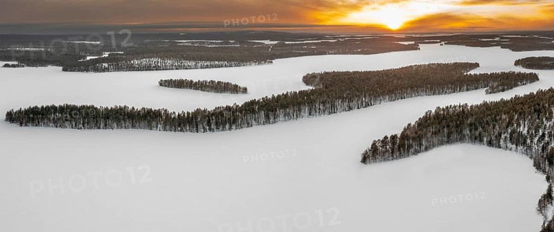 Aerial view over forest and snow covered frozen LahnaselkÃ¤ lake in Kuusamo in winter, Koillismaa, Northern Ostrobothnia region, Finland, Scandinavia