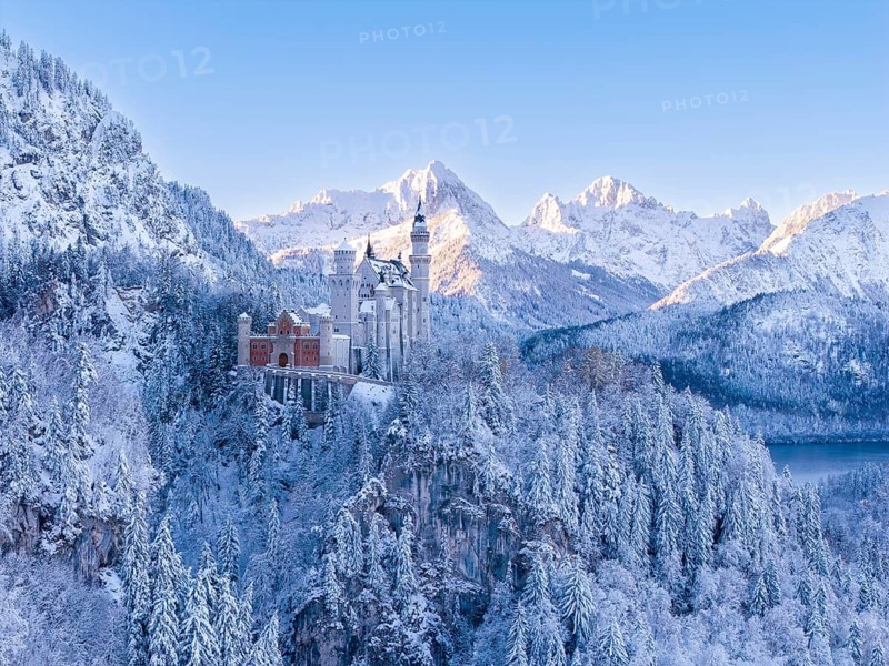 Neuschwanstein Castle rises majestically in a secluded winter landscape surrounded by mountains and snow, Schwangau near FÃ¼ssen, OstallgÃ¤u, AllgÃ¤u, Bavaria, Germany