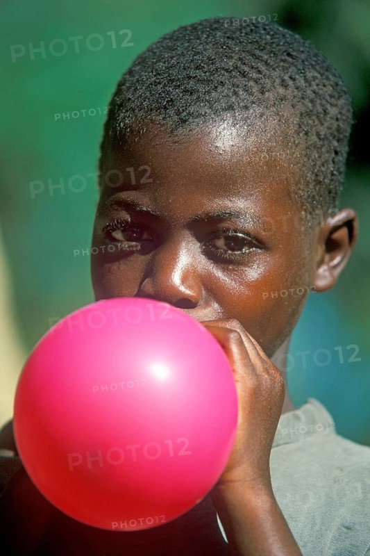 Local boy inflating balloon, Kande, Malawi, Africa, July 2000, vintage, retro, old, historic