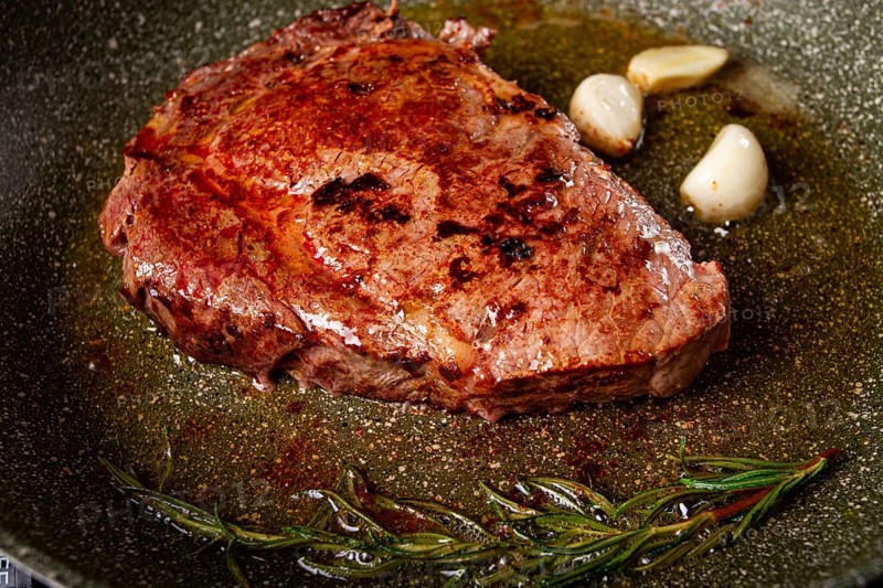 Fried steak, beef steak, rib eye steak, in a frying pan, top view, no people