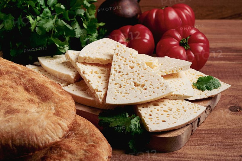 Georgian sliced cheese, on a wooden chopping board, with tomatoes with herbs and lavash, rustic style, Georgian cuisine, no people