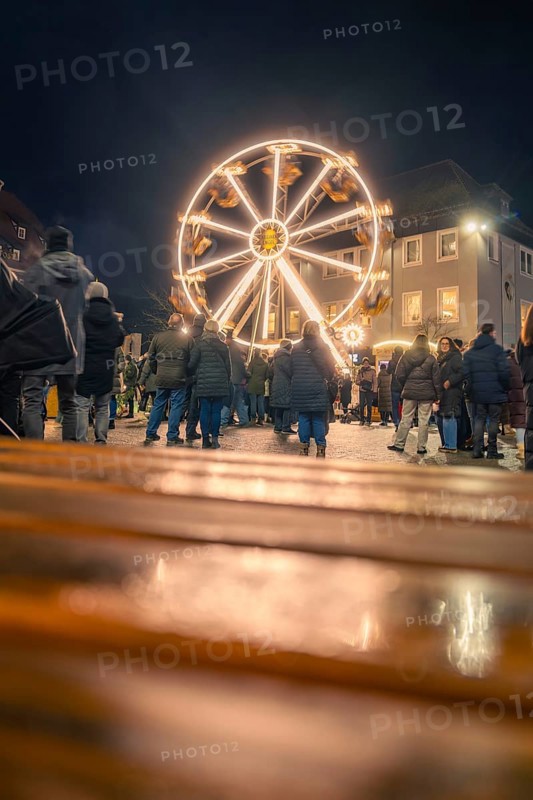People come together to enjoy an illuminated Ferris wheel at night, Christmas market 2025, Nagold, Black Forest, Calw district, Germany