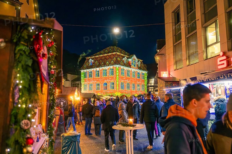 Building with festive light projection on a busy Christmas market, Christmas market 2025, Nagold, Black Forest, Calw district, Germany