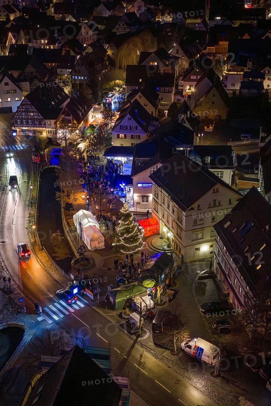 Aerial view of an illuminated Christmas market at night with a shiny Christmas tree and crowds of people, Aidlingen Christmas market, BÃ¶blingen district, Germany