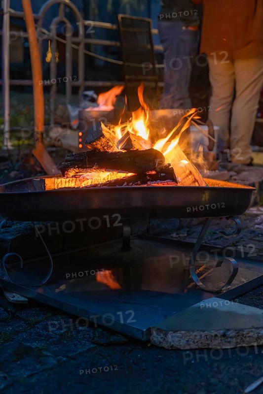 A burning fire provides warmth and comfort on a cool night, Aidlingen Christmas Market, Böblingen District, Germany