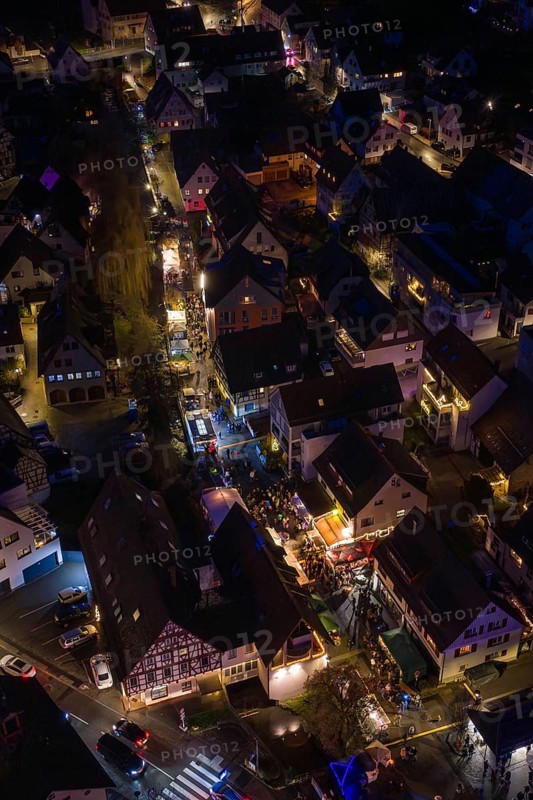Village at night with tight street lights and festive lights, Aidlingen Christmas market, Böblingen district, Germany