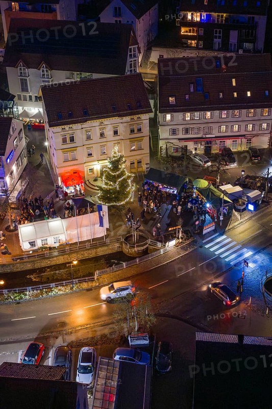Night view with decorated Christmas tree and people gathered, Aidlingen Christmas market, Böblingen district, Germany