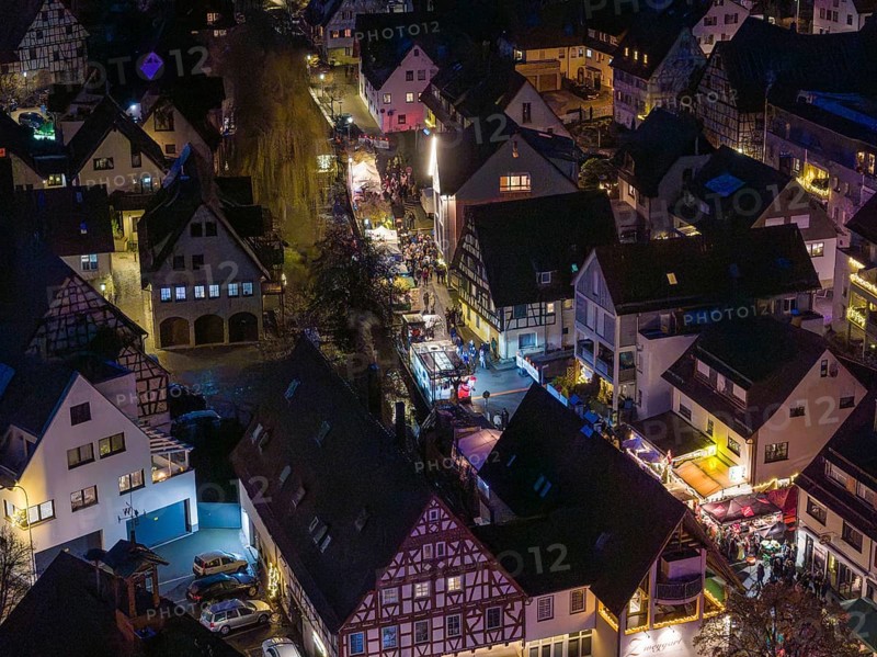 Night view of a village with illuminated half-timbered houses and roads, Aidlingen Christmas market, Böblingen district, Germany
