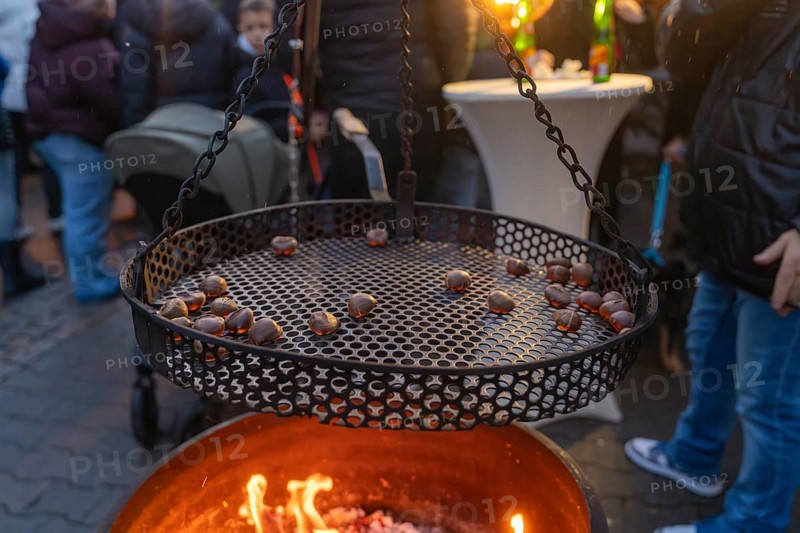 Cosy grilling of chestnuts at a market in the evening, Aidlingen Christmas market, Böblingen district, Germany