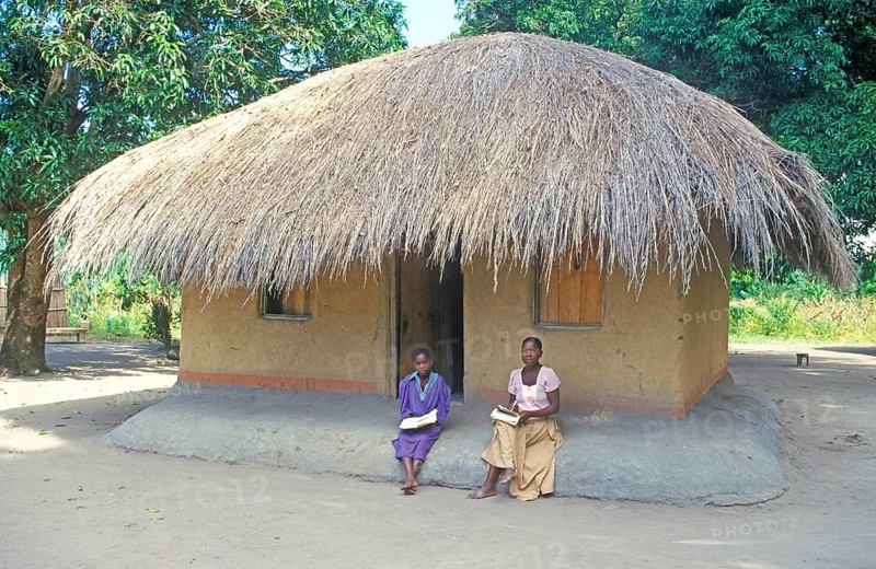 Two woman in front of a thatched house near Kande, Lake Malawi, Africa, July 2000, vintage, retro, old, historic