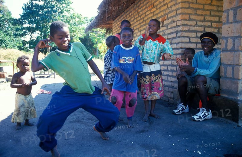 Local children dance happily to music in a village near Kande, Lake Malawi, Malawi, Africa, July 2000, vintage, retro, old, historic