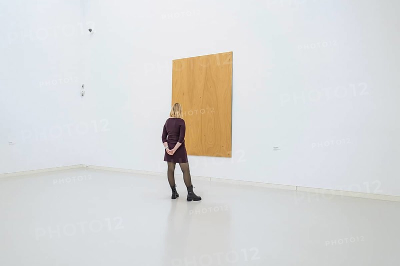 Woman looking at a large, simple, wooden work of art in a minimalistic space, Open Horizons exhibition, Schauwerk Sindelfingen, Böblingen district, Germany