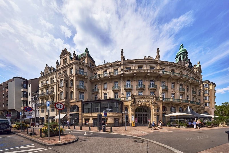 Historic building, former hotel palace hotel, barrier bollard, street, round faÃ§ade with windows, catering, outdoor area, restaurant, parking strips with vehicles, pedestrians as accessories, blue sky, cirrostratus clouds, cumulus clouds, wreath ground, Wiesbaden, state capital, district-free city, Hesse, Germany