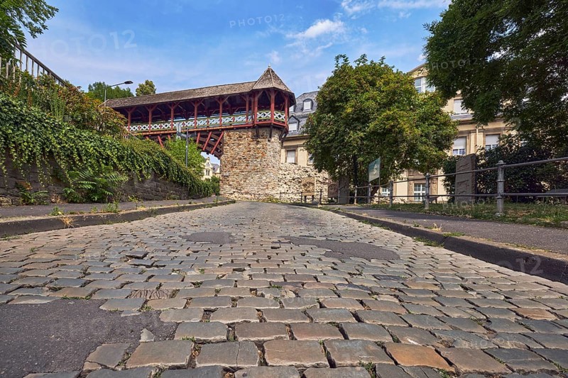 Heidenmauer, historicizing city gate Römertor, city fortification, lantern, metal fence, trees, bushes, cobblestone street, frog-eye view, blue sky, cumulus clouds, cirrus clouds, street Am Römertor, Wiesbaden, state capital, district-free city, Hesse, Germany