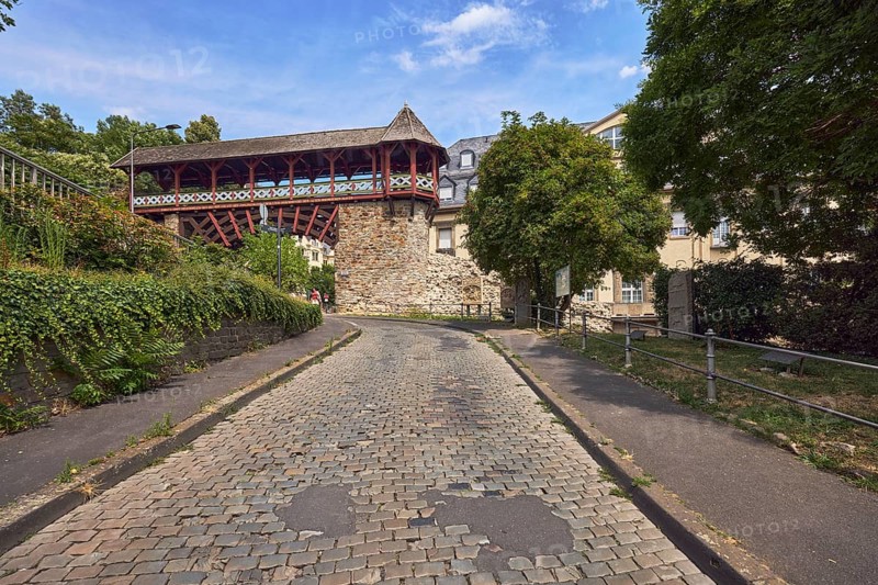 Heidenmauer, historicizing city gate Römertor, city fortification, lantern, metal fence, trees, bushes, cobblestone road, blue sky, cumulus clouds, cirrus clouds, street Am Römertor, Wiesbaden, state capital, district-free city, Hesse, Germany
