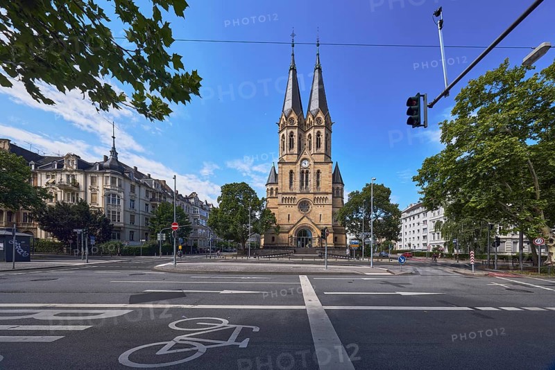 Evangelische Ringkirchengemeinde, church, neo-Romanesque architectural style, architect Johannes Otzen, general architecture, houses, buildings, street, cycle path, road marking BUS, lanes, directional arrows, traffic lights, trees, branches, blue sky, altocumulus clouds, intersection RheinstraÃŸe, Kaiser-Friedrich-Ring and An der Ringkirche, BundesstraÃŸe B54, Wiesbaden, state capital, district-free city, Hesse, Germany