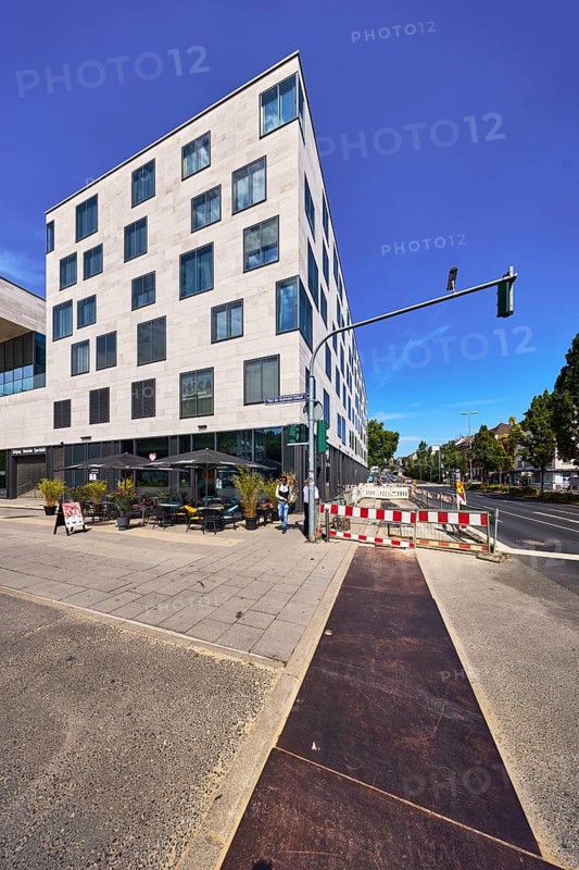 Commercial building, modern architecture, outdoor area of a restaurant, waffle house, fenced construction site, barrier, road construction, traffic lights, pedestrians as accessories, deep blue sky, cirrus clouds, intersection of Schwalbacher StraÃŸe with German Unity Square, Wiesbaden, state capital, district-free city, Hesse, Germany