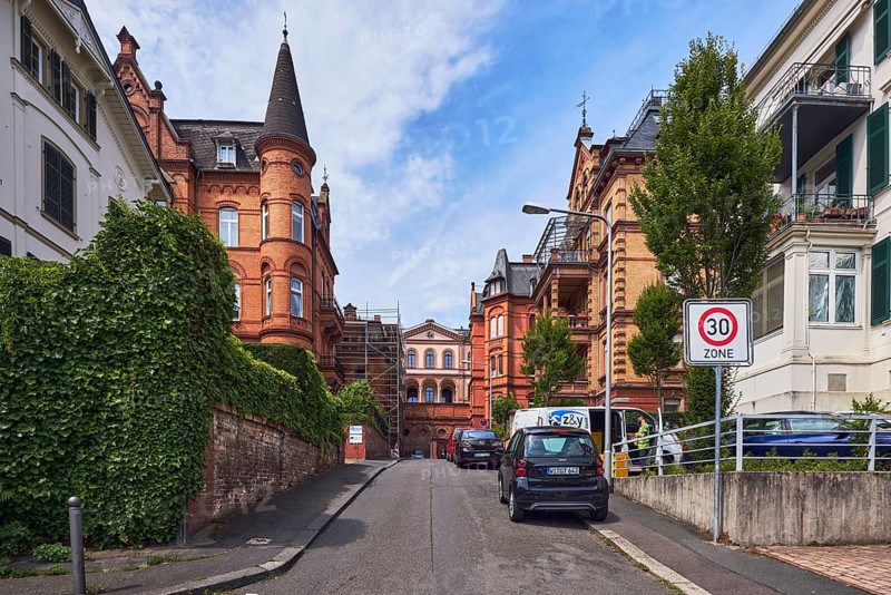 Houses, historic residential buildings, concrete wall, brick wall, trees, hedge, zone 30 sign, blue sky, cumulus clouds, street An der alten Synagoge, Wiesbaden, state capital, district-free city, Hesse, Germany