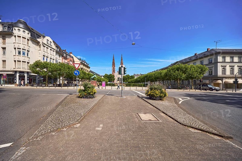 Traffic island, roads, square, St. Boniface Catholic Church, scaffolding, renovation, barrier bollard, pedestrian crossing, traffic lights, traffic signs, right of way, prescribed direction of travel left, flower pots, general architecture, houses, buildings, trees, blue sky, cirrus clouds, intersection RheinstraÃŸe with Luisenplatz and AdolfstraÃŸe, Wiesbaden, state capital, district-free city, Hesse, Germany