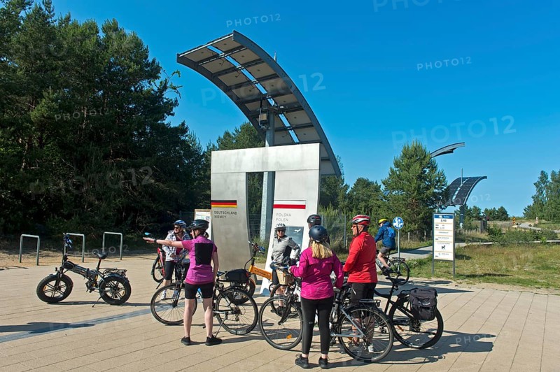 Cyclists at the symbolic gate on the border between Germany and Poland on the Europa Promenade, Ahlbeck, Usedom island, Mecklenburg-Western Pomerania, Germany