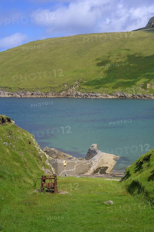 Rusted winch above small harbour, Portacloy loop cliff walk, Muingnabo, County Mayo, Ireland