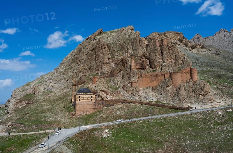 A mountain fortress with roads in the foreground surrounded by steep rocks under a bright blue sky, Eski BayezÄ±d Cami, Old Bayezid Mosque and DoÄŸubayazÄ±t Castle, Dogubayazit, DoÄŸubayazÄ±t, DoÄŸubeyazÄ±t, Agri Province, AÄŸrÄ±, Eastern Anatolia, Anatolia, Turkey
