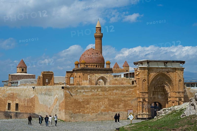 A historic building with a sandstone dome and minaret, surrounded by an old wall, under a blue sky, Ishak Pasha Palace, Ishak Pasa SarayÄ±, Ottomans, Dogubayazit, DoÄŸubayazÄ±t, DoÄŸubeyazÄ±t, Agri Province, AÄŸrÄ±, Eastern Anatolia, Anatolia, Turkey