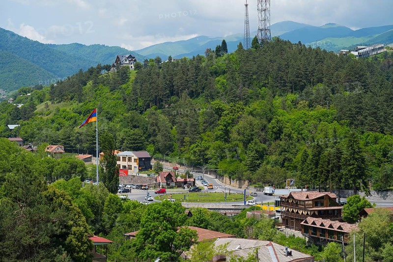 Panorama with mountains, forest, village, a flag and a road leading through the green landscape, view of Dilijan, Delijan, Delijan, Tavush province, Armenia