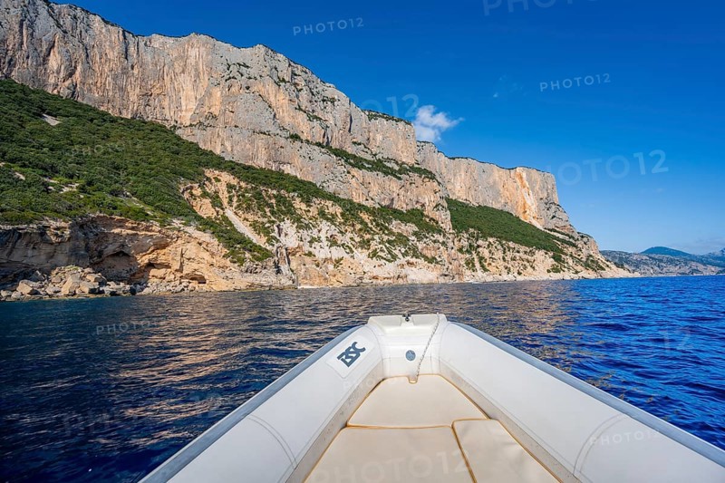 Motorboat trip along the picturesque rocky coast, cliffs and blue sea, Golfo di Orosei, Baunei, Sardinia, Italy