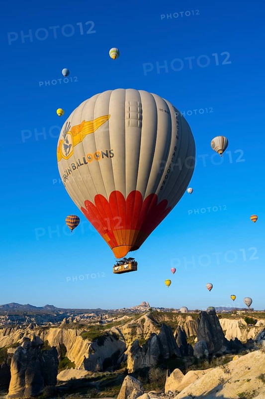 A large colorful balloon with decoration floats over a picturesque rocky landscape, hot air balloons, Göreme National Park, Göreme Tarihî Millî ParkÄ±, Nevsehir Province, NevÅŸehir, Cappadocia, Cappadocia, Central Anatolia, Turkey