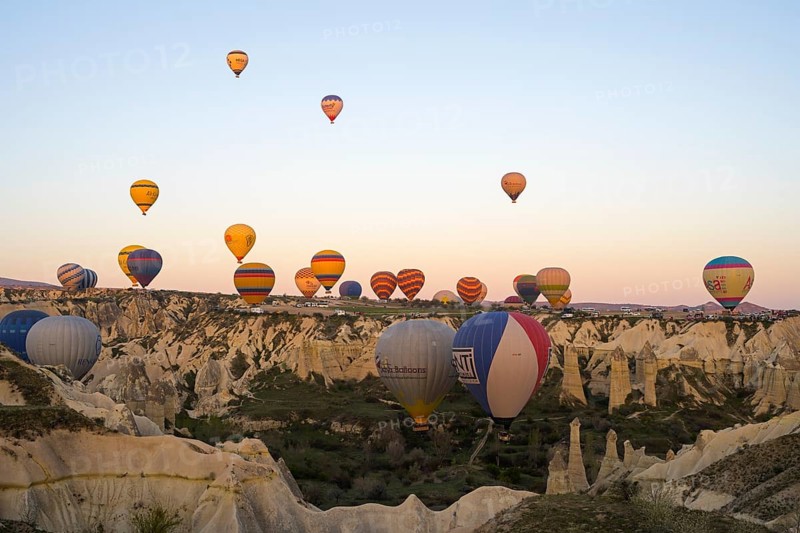 Hot air balloons float over a rocky landscape at dawn, bright colors create a peaceful atmosphere, Göreme Tarihî Millî Park, Nevsehir Province, Nevsehir, Cappadocia, Capadocia, Cappadocia, Cappadocia, Central Anatolia, Turkey