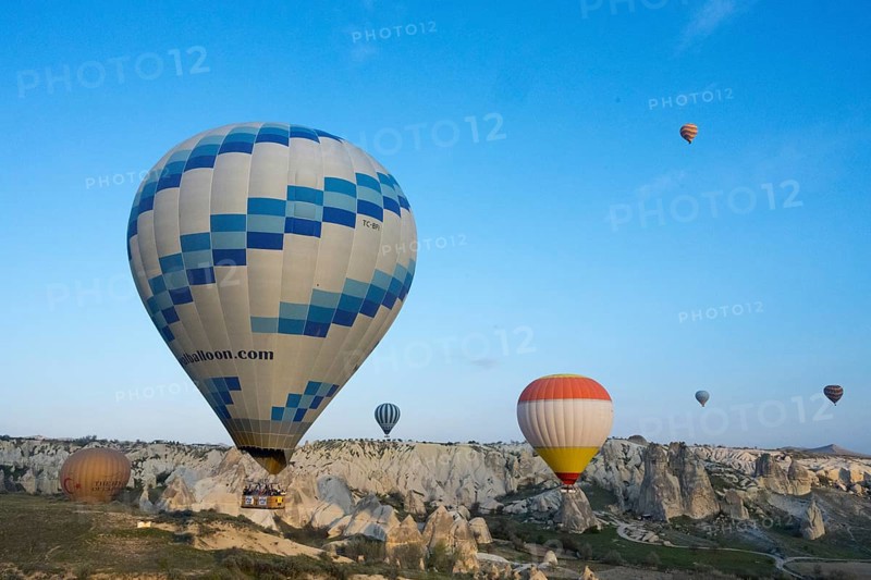 Hot air balloons of various colors float over a picturesque landscape and stand out against the blue sky, Göreme National Park, Göreme Tarihî Millî ParkÄ±, Nevsehir Province, NevÅŸehir, Cappadocia, Cappadocia, Central Anatolia, Turkey