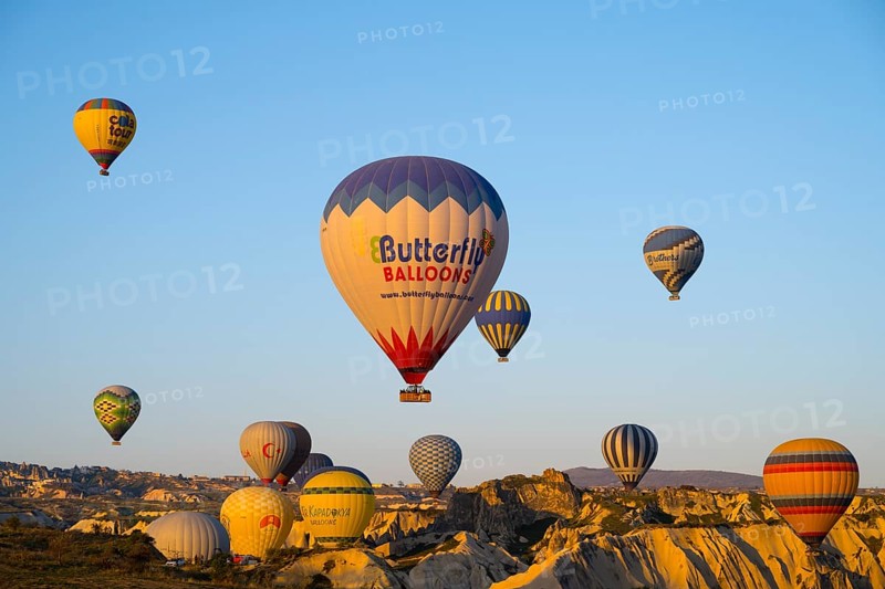 Many colorful hot air balloons rise over rocks early in the morning, Göreme National Park, Göreme Tarihî Millî Park, Nevsehir Province, Nevsehir, Cappadocia, Cappadocia, Central Anatolia, Turkey