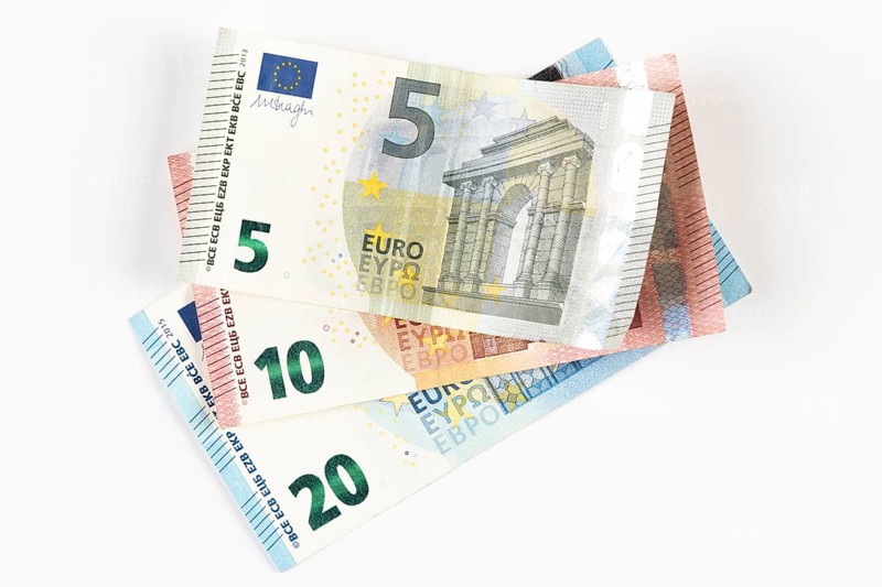Stacked euro banknotes in denominations of 5, 10 and 20 on a white background