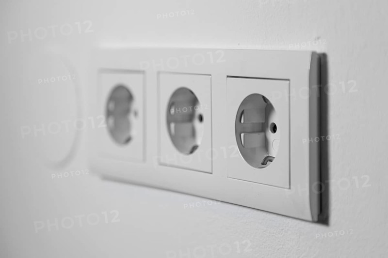 White triple outlet on a white wall