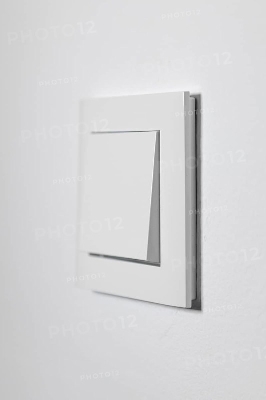 White light switch on a white wall, minimalistic design