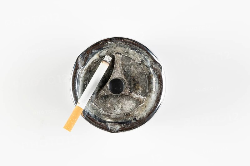 Used ashtray with cigarette, on white background